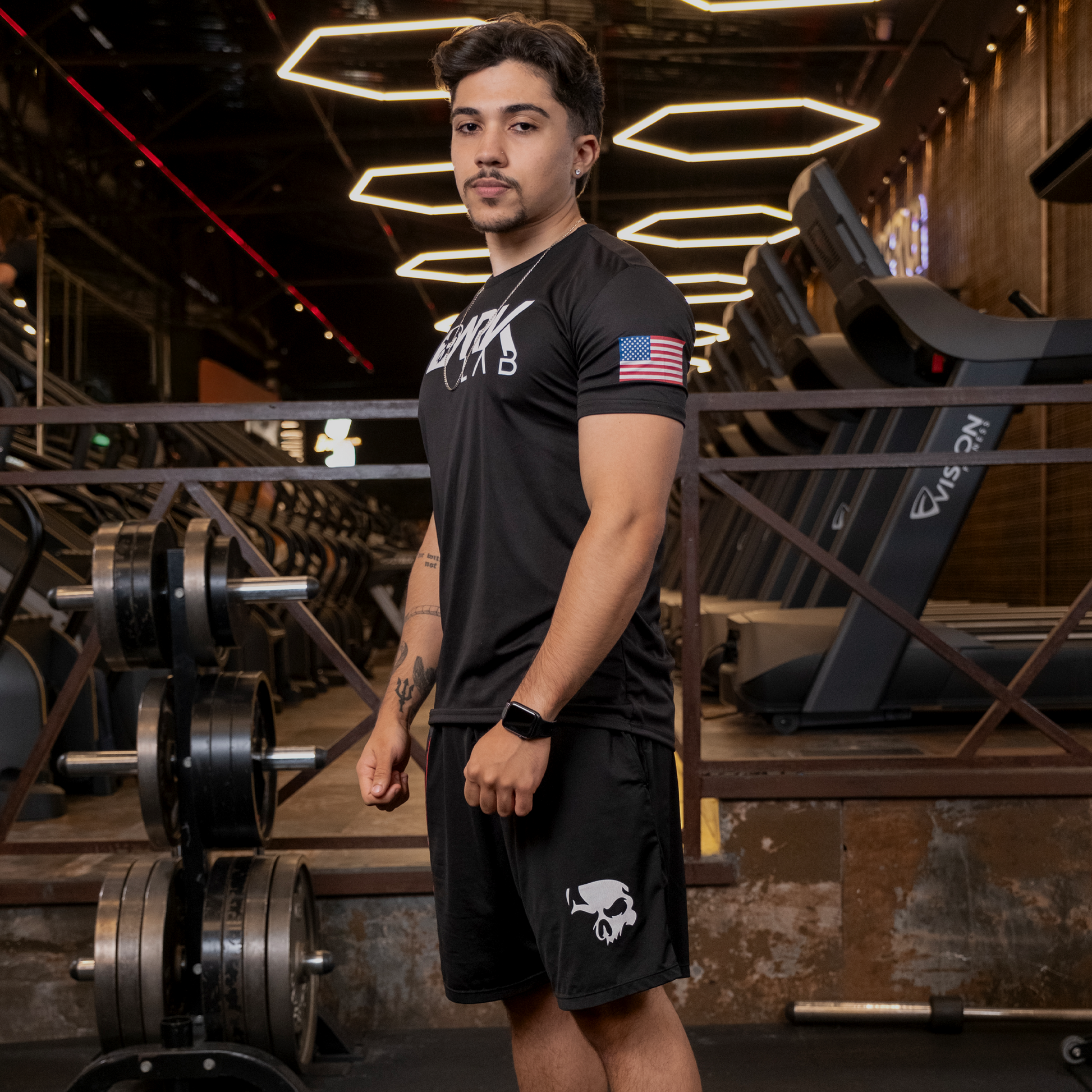 Homem de perfil na academia mostrando a bermuda masculina da Dark Lab 