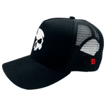 Boné Trucker da marca Dark Lab em parceria com a BLCK visto de lado com a caveira símbolo da Dark Lab na frente e a logo da BLCK na lateral.