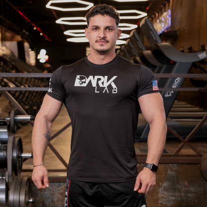 Homem de frente na academia usando Camiseta de Caveira para Treino da Dark Lab. A camiseta da logo tem a logo da marca na região frontal.
