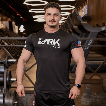 Homem de frente na academia usando Camiseta de Caveira para Treino da Dark Lab. A camiseta da logo tem a logo da marca na região frontal.