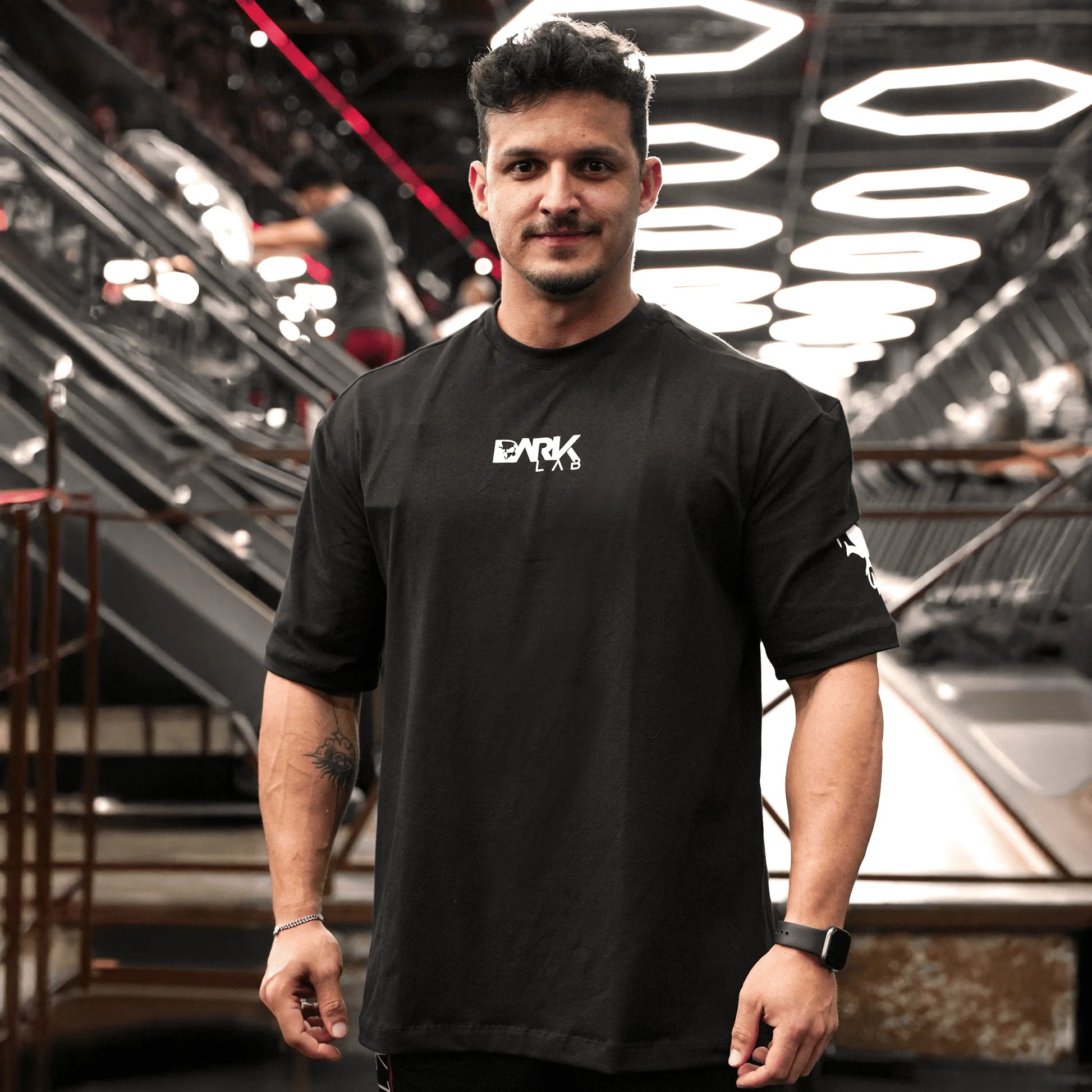 Homem na academia usando a camiseta Welcome To The Future da Dark Lab com a logo da dark lab na parte da frente 