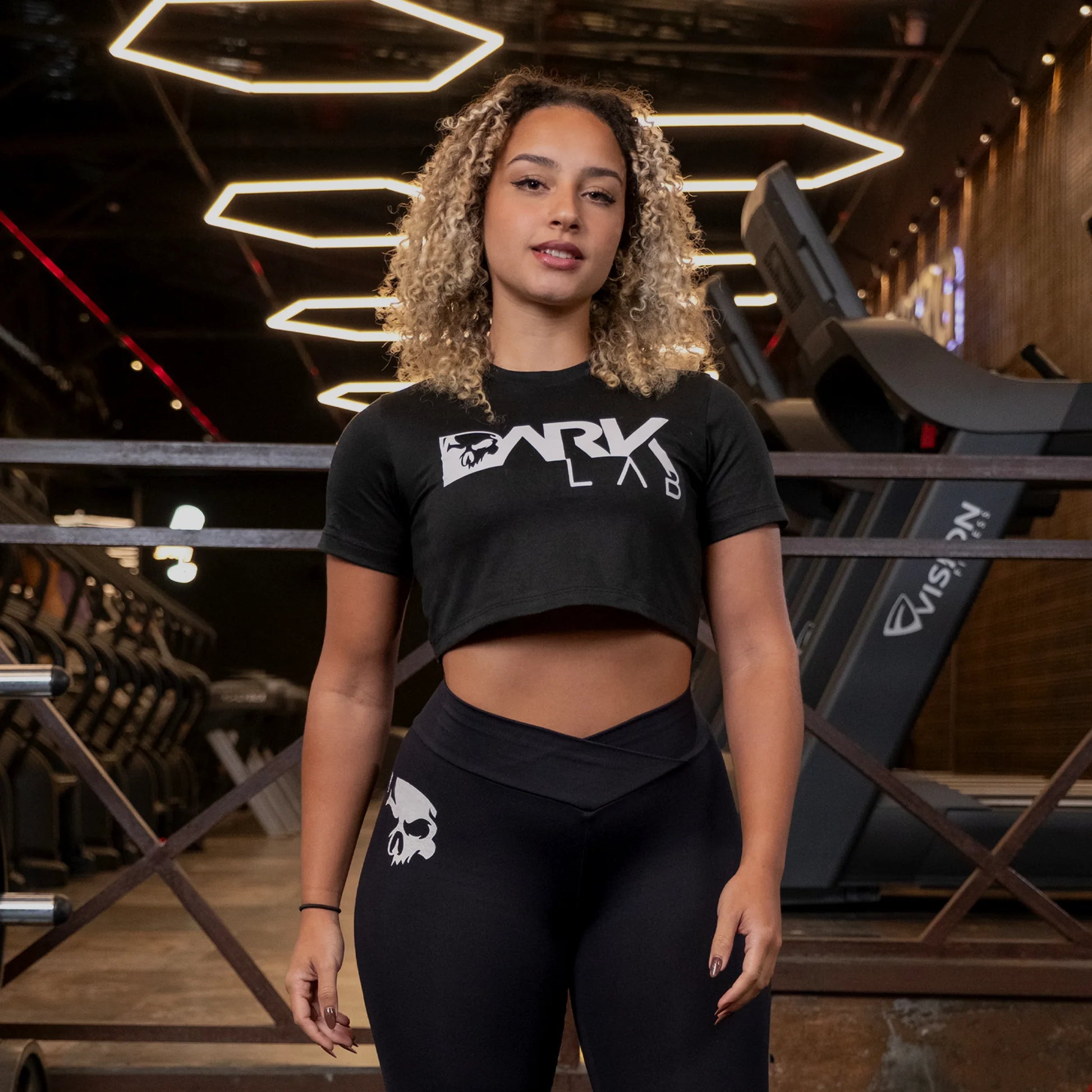 Mulher na academia usando o Cropped Fitnes preto da Dark Lab