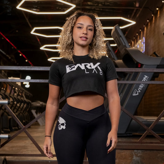 Mulher na academia usando o Cropped Fitnes preto da Dark Lab